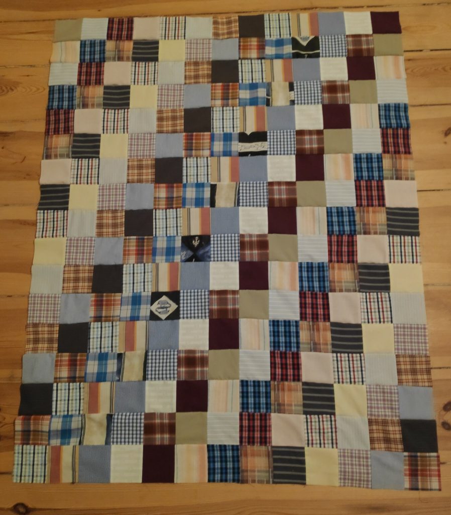 Patchworkdecke aus verschieden gemusterten Stoffquadraten.